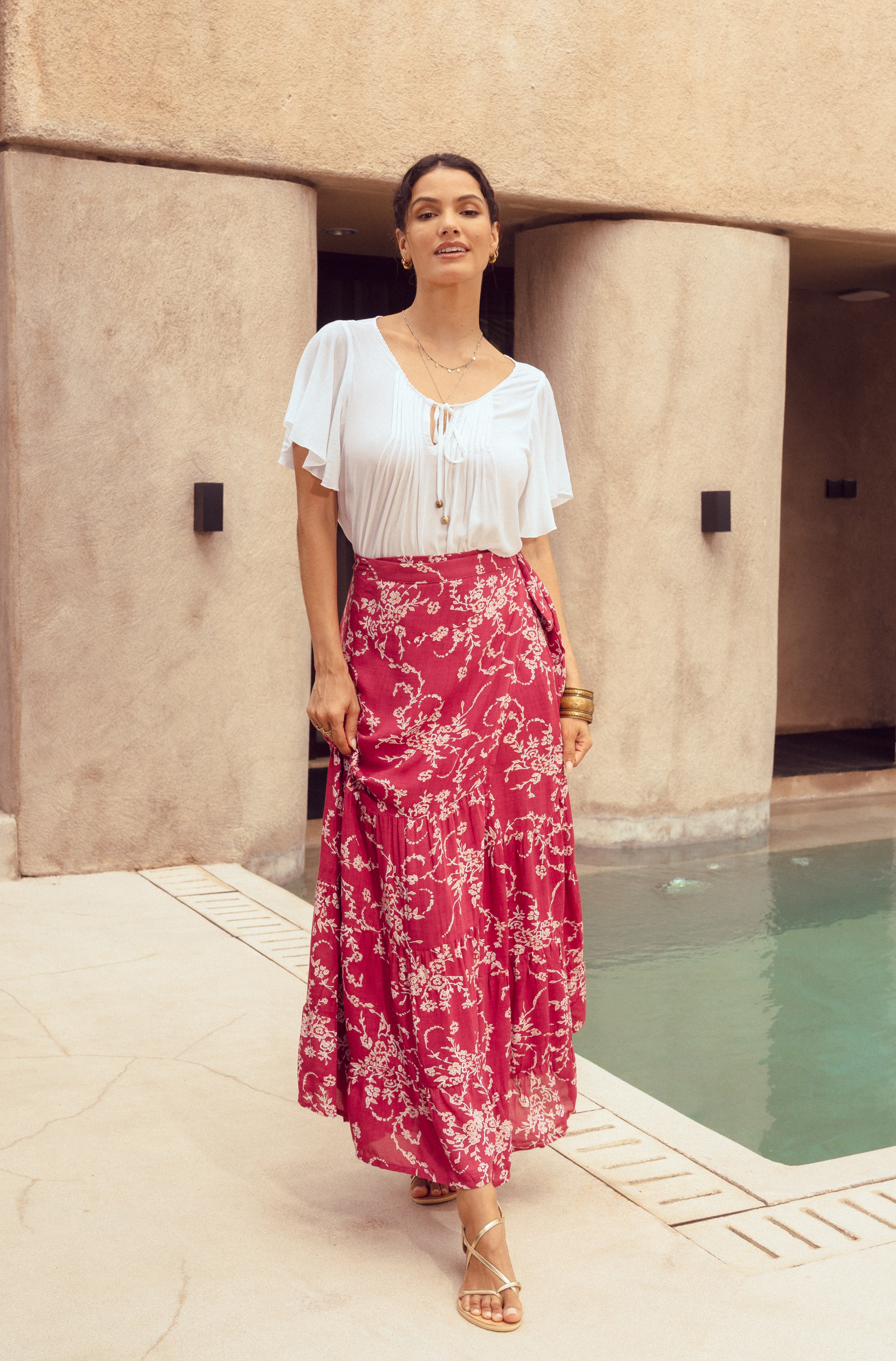 Woman in white blouse and red floral maxi wrap skirt