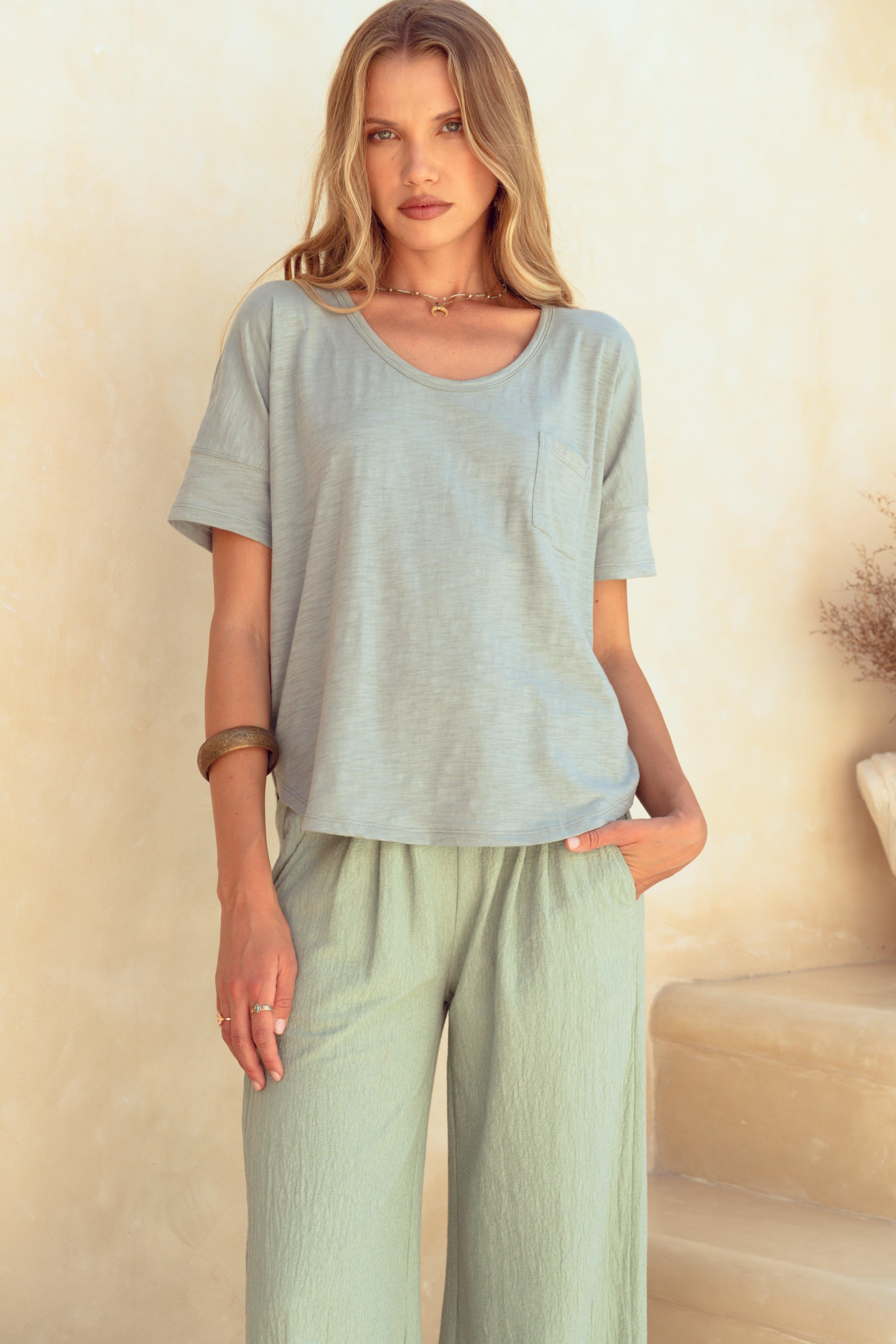 Woman wearing a light green outfit against a neutral background